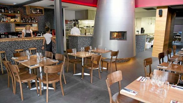 A tall pizza oven, with porthole window, dominates the room.