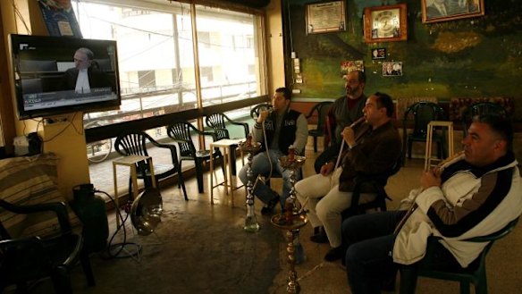 Lebanese men watch the opening of the trial in absentia of four men accused of murdering former Lebanese prime minister Rafiq al-Hariri in 2005.
