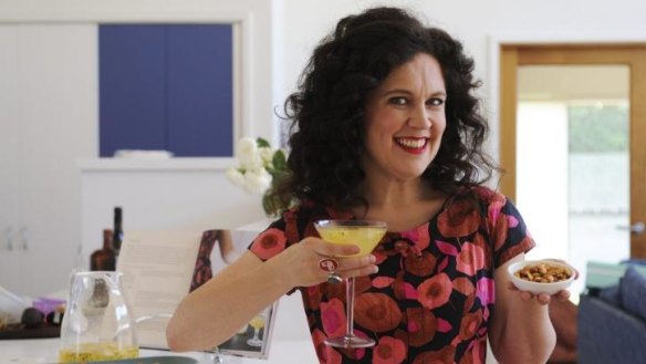 Party food: Annabel Crabb with her passionfruit cocktail and spicy nuts.