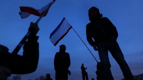 People wave Russian flags in Lenin Square to celebrate the Crimean referendum  in Simferopol on Sunday.
