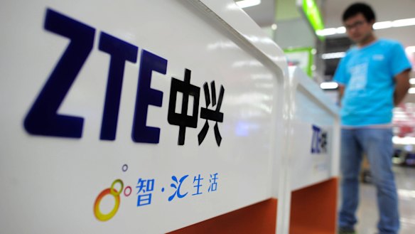 A salesperson stands at counters selling mobile phones produced by ZTE Corp. at an appliance store in Wuhan in central China's Hubei province. 