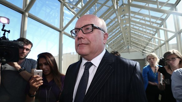 Attorney-General Senator George Brandis  departs after addressing the media in the press gallery on Thursday.