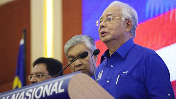 Najib Razak, Malaysia's outgoing prime minister, right, speaks during a news conference at the Barisan Nasional coalition headquarters in Kuala Lumpur, Malaysia, on Thursday.