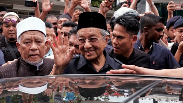 Malaysian Prime Minister Mahathir Mohamad, centre, waves to crowds leaving National Mosque after performing Friday prayers in Kuala Lumpur.