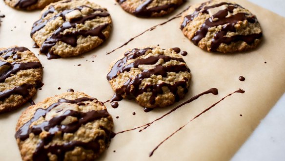Oat and tahini cookies drizzled with dark chocolate.