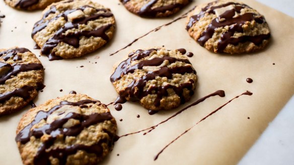 Oat and tahini cookies drizzled with dark chocolate.