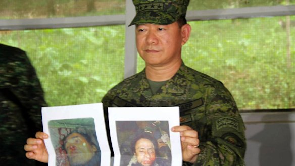 Philippine military chief General Eduardo Ano holds pictures of dead militant leaders during a press conference at a military camp in Marawi.
