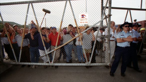 Picketers push up against a fence holding them out of Swanson Dock, Melbourne. April 8, 1998.