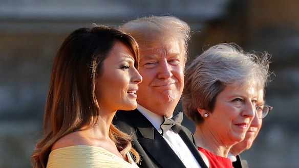 President Donald Trump, second from the right, smiles as he listens to first lady Melania Trump, far left, speak as they stand with British Prime Minister Theresa May at Blenheim Palace.