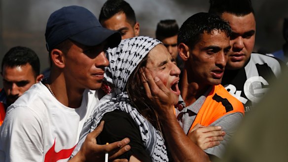 Palestinians help an injured woman during clashes with Israeli troops after a protest in solidarity with prisoners  in the West Bank city of Ramallah.