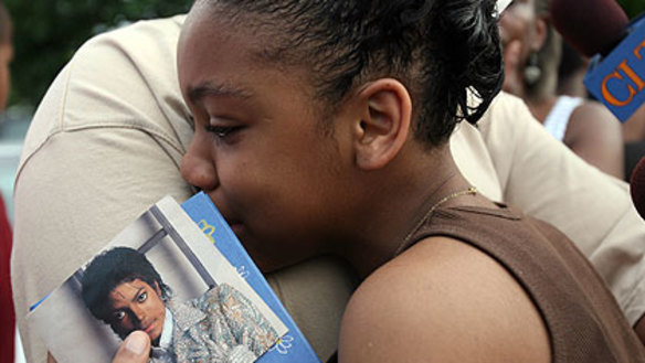 A young fan grieves outside  Michael Jackson's former home.
