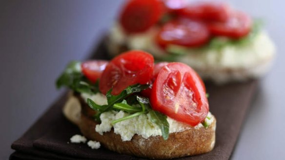 Ricotta cheese on toast with sliced tomatoes and rocket