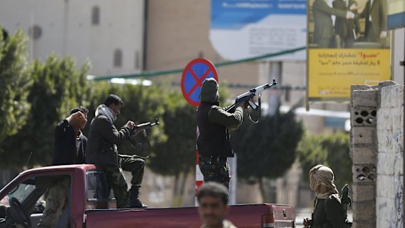 A Houthi fighter fires at forces guarding the Presidential Palace.