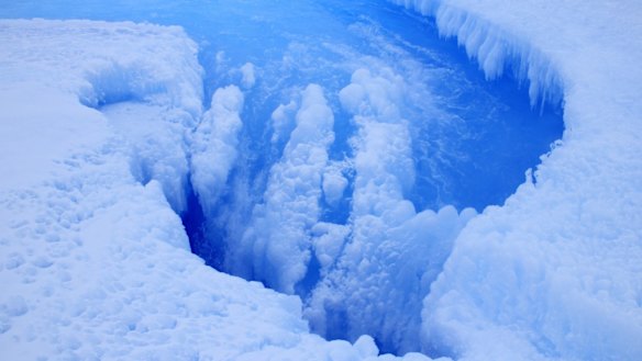 Moulin inside the crater on the Roi Baudouin ice shelf showing the drainage of meltwater.