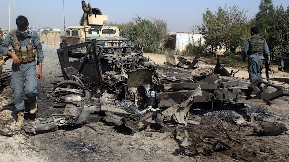 Afghan security forces inspect the site of a US air strike in Kunduz city, north of Kabul, on Friday.