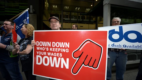 Meatworkers union members protest outside the shop assistants' union over its wages deal with Coles.