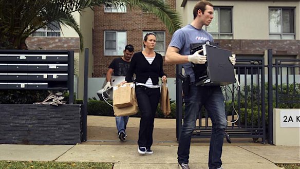 Victim: Police carrying evidence leave the block where Henry Kwan fell to his death.