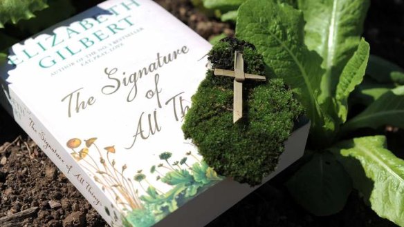 <I>The Signature of All Things </I> book with fresh moss and a Palm Sunday cross from St John's Church, Reid.