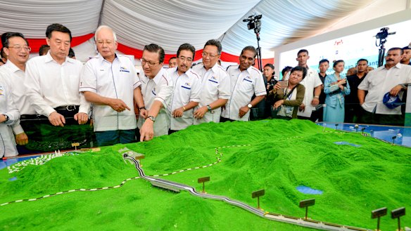 Former Malaysian prime minster Najib Razak, third from left, looks at models of the East Coast Rail Link.