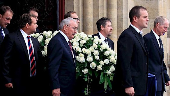 Jim Stynes' casket is carried from the service by pall bearers.