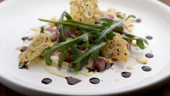 Balsamic vinegar is drizzled over the beef carpaccio.