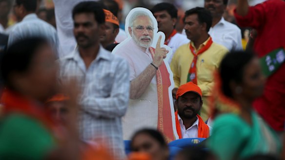 A cut-out of Indian Prime Minister Narendra Modi stands amidst the crowd during an election campaign rally in Bangalore.