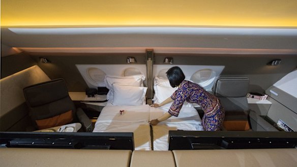 A flight attendant arranges a bed in two adjoining suites on a Singapore Airlines Airbus A380.