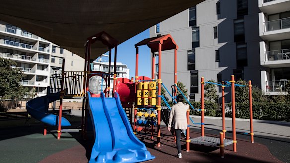 Peg Patterson Park, Rhodes, Sydney is almost deserted except for a mother stretching while her baby sleeps in the pram. 