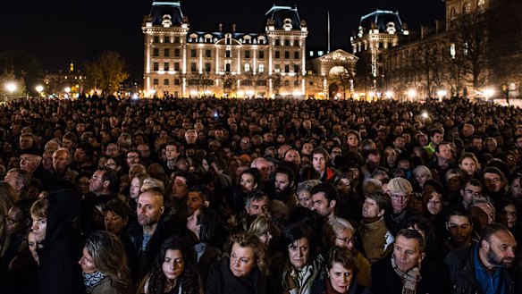 People gather outside of Notre Dame Cathedral ahead of a ceremony to the victims terrorist attacks on November 15, 2015 in Paris.