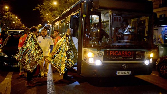 Survivors from the Bataclan Eagles of Death Metal concert, where the Australian was headed, board a bus after the attack. 