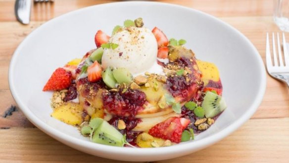 Buttermilk hotcake stack with raspberry compote, lemon curd, fruit salad, pistachios and vanilla bean ice-cream.