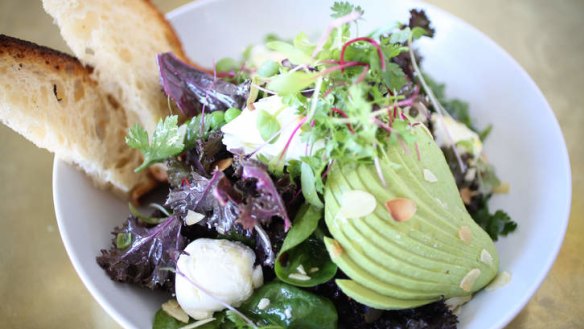 The breakfast salad includes greens, avocado and almond flakes.