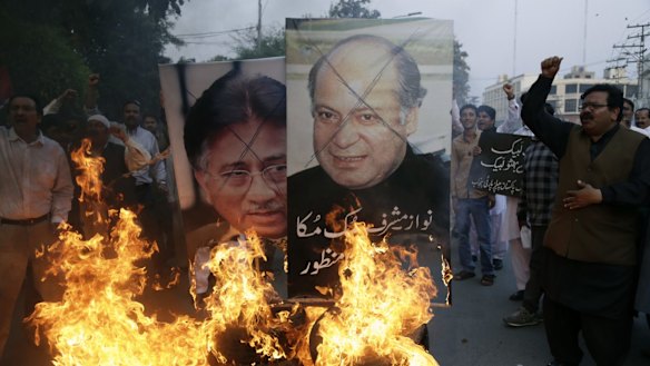 Protesters burn pictures of Pakistani political leaders past and present in Lahore before this week's attack. Pakistan has become a bitterly divided nation.