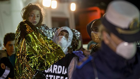 A migrant is helped disembark in Pozzallo after being rescued.