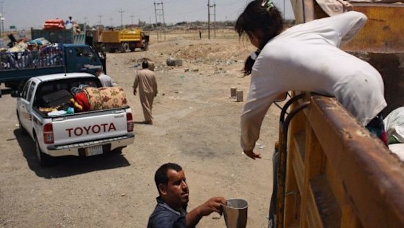 Iraqis parked by the side of the highway after crossing a checkpoint south of Kirkuk into the Kurdish Peshmerga-controlled zone.