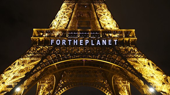 Slogans were projected on the Eiffel Tower as the climate conference in Paris pushed into overtime.