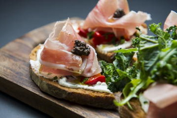 The Prosciutto tartine with basil ricotta, roasted red capsicum, tapenade, prosciutto and rocket.