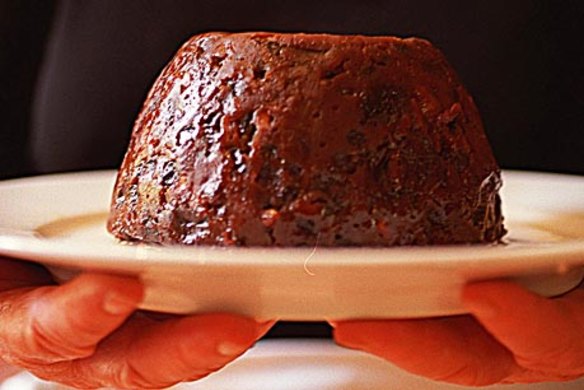 Stephanie Alexander holding Emily Bell's Christmas Pudding on a platter.