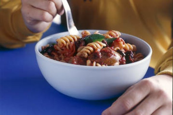 Spiral pasta with sausage, tomato and olives.