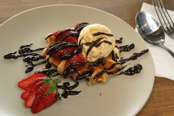 Belgian-style waffle with vanilla ice-cream, strawberries and chocolate sauce.