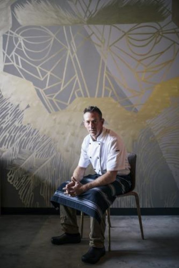 Co-owner of new paleo cafe, Elemental, Daniel Barrett, in front of the George Rose mural in the cafe.