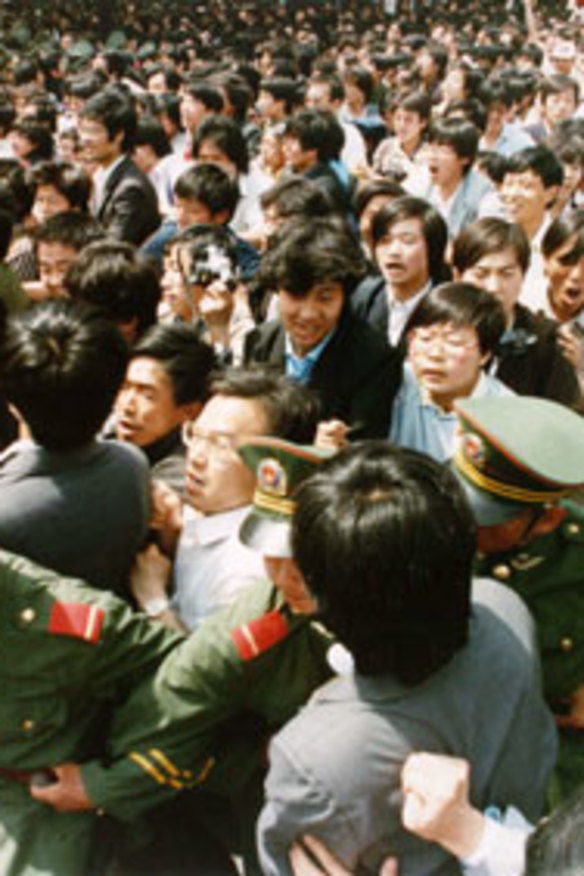 Crowds of students surge through a police cordon before pouring into Tiananmen Square during a pro-democracy demonstration on June 4, 1989.