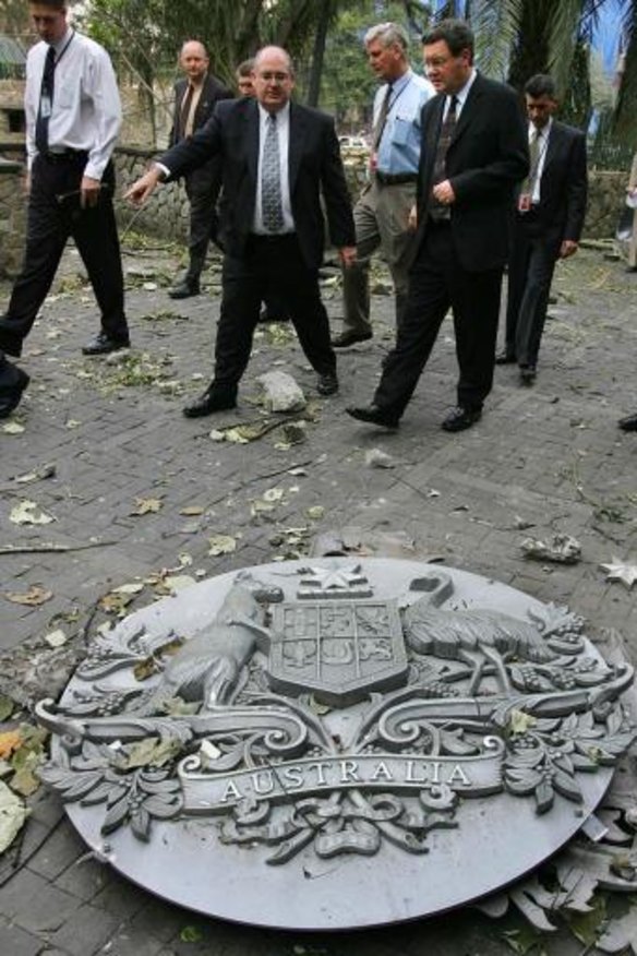 Australia's then Foreign Minister Alexander Downer inspects the damage with Ambassador David Ritchie.