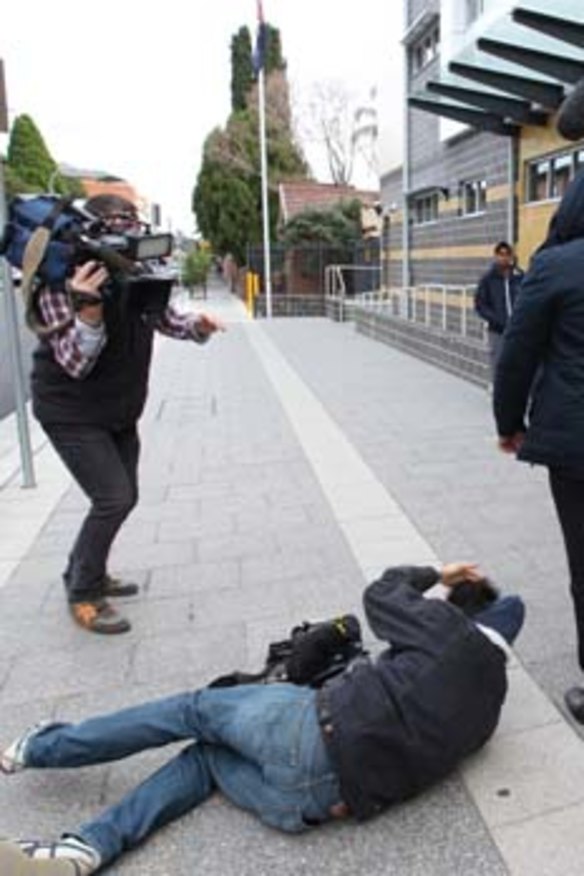 Unconscious … Channel Nine cameraman Mario Conti on the footpath after being attacked outside court yesterday.