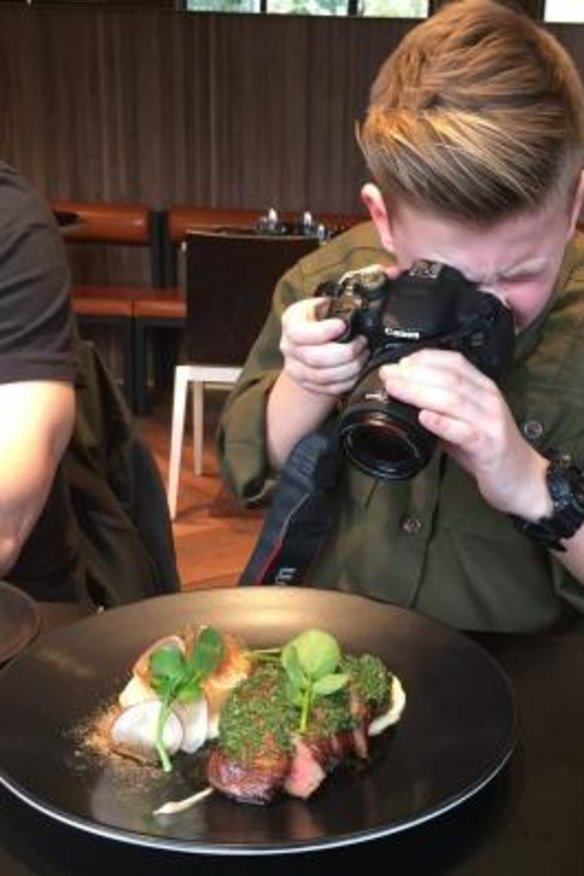 The young blogger focuses his lens on a dish.