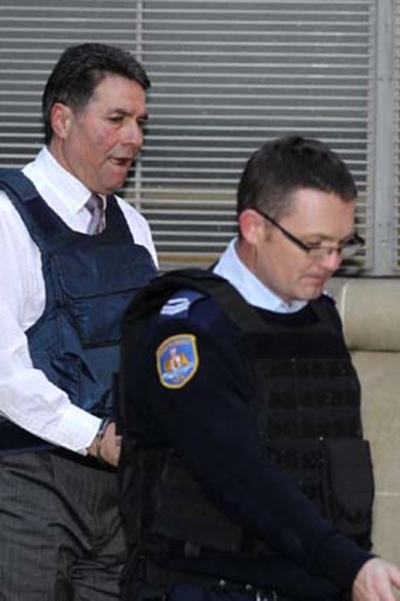 Former boxing champion Lucky Gattellari being led away from court after being sentenced over his role in the 2009 murder of Michael McGurk.