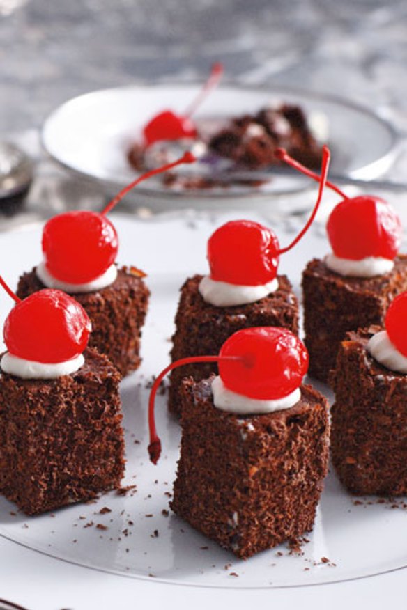 Mini black forest cakes topped with maraschino cherries.