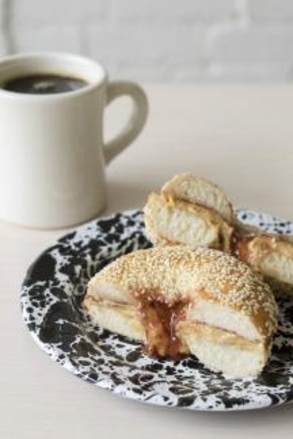 Sesame-seed bagel sandwiched with peanut butter and raspberry jam.
