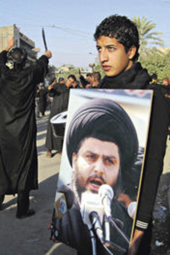 Willing spirits … an Iraqi youth in Baghdad holds a placard of radical Shiite cleric Muqtada al-Sadr.