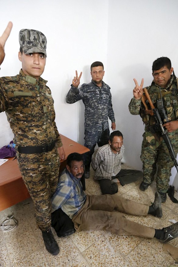 Shiite paramilitary fighters and Iraqi security forces arrest Islamic State militants in Tikrit this week.